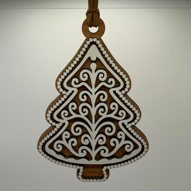 hanging ornament wood gingerbread tree with dark wood and white frosting overlay hanging on a brown cord