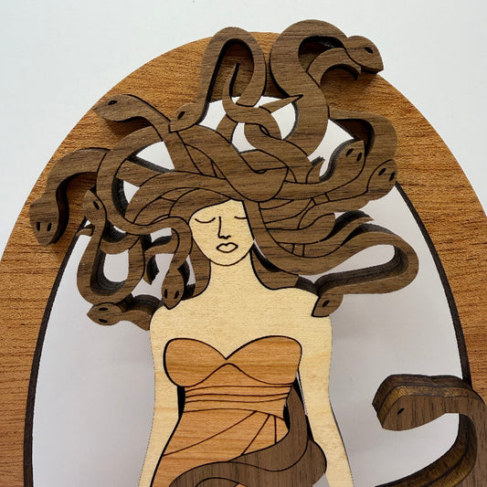 Close-up of the wooden Medusa shelf sitter showing the snakes in her hair and contrasting wood grain