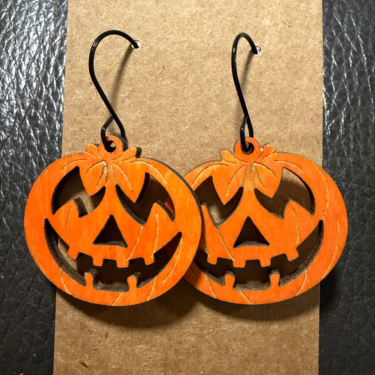 Orange jack-o'-lantern earrings shown from another angle