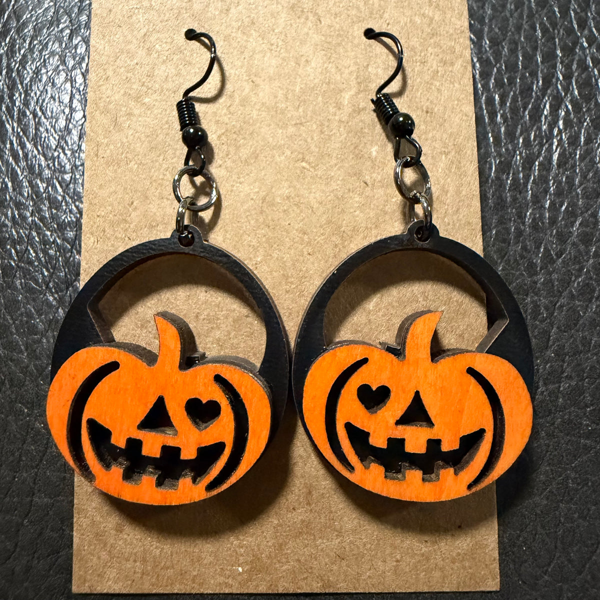 Orange and black jack-o'-lantern earrings shown from another angle