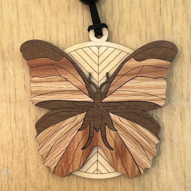 Wooden butterfly ornament on a wooden surface