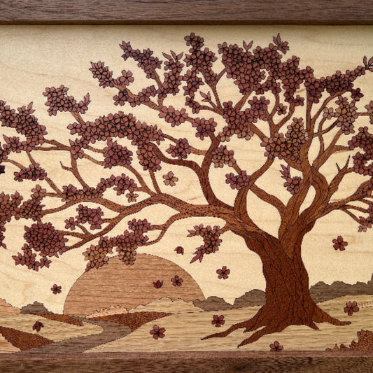 Handmade wood art inlay featuring a cherry blossom tree at sunset with cedar, mahogany, oak, cherry, walnut, and maple woods, set in a walnut frame