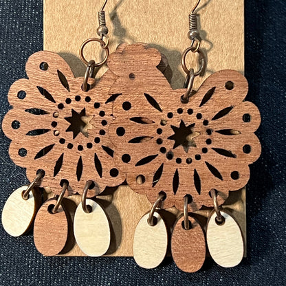 Wood dangling earrings featuring a chicken with three hanging eggs