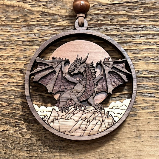 Wooden pendant with a laser-cut dragon design on a wooden surface