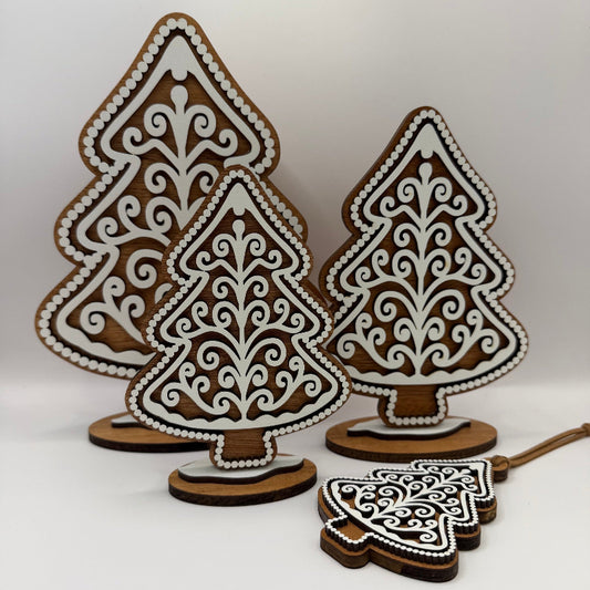 set of four handcrafted wood gingerbread trees with white frosting detail in graduated sizes, plus a hanging ornament