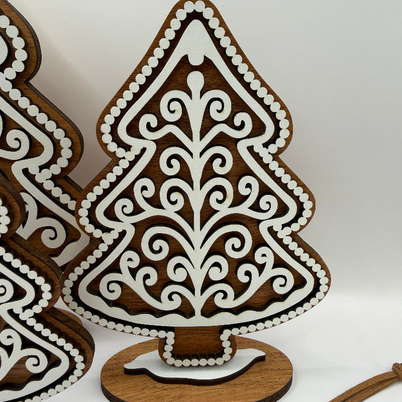 close up of a gingerbread style wood tree with dark wood background and white frosting overlay
