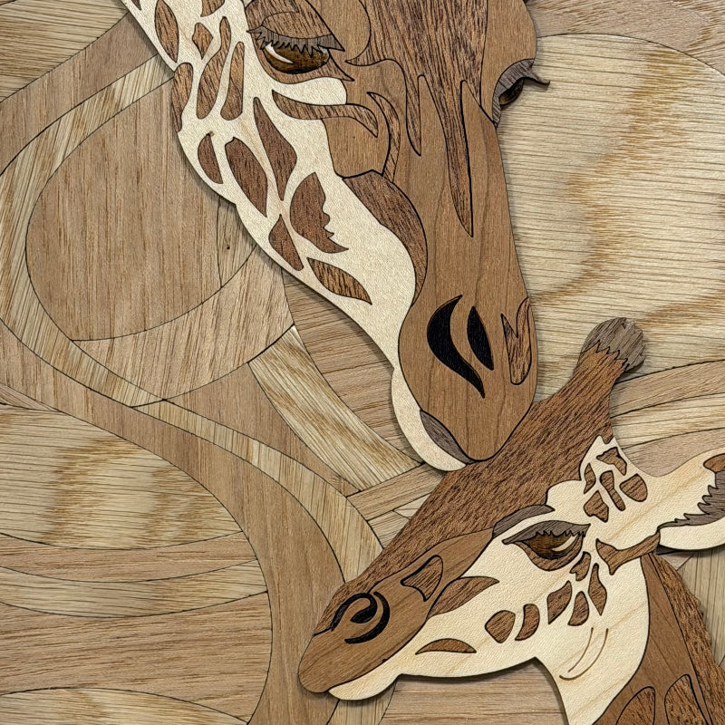 Close-up of a wooden giraffe mosaic artwork showing layered natural wood pieces forming a giraffe face and neck against a matching wood-grain background.