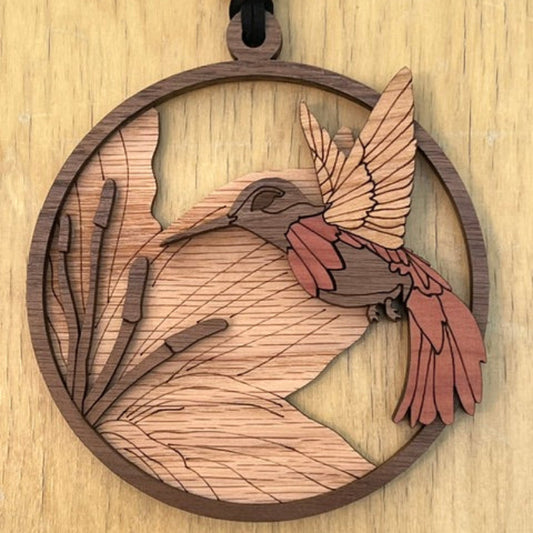 Wooden pendant with hummingbird design on a wooden surface