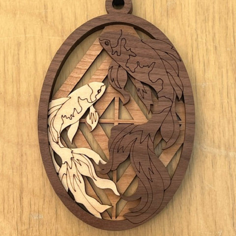Wooden decorative item with koi fish laser-cut designs on a wooden surface