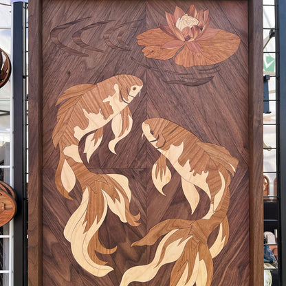 Handmade wood intarsia wall art of two koi fish swimming beneath a lotus flower, 17x28 inches, framed in walnut