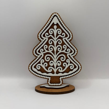 wood gingerbread tree with dark wood background and white swirly frosting overlay
