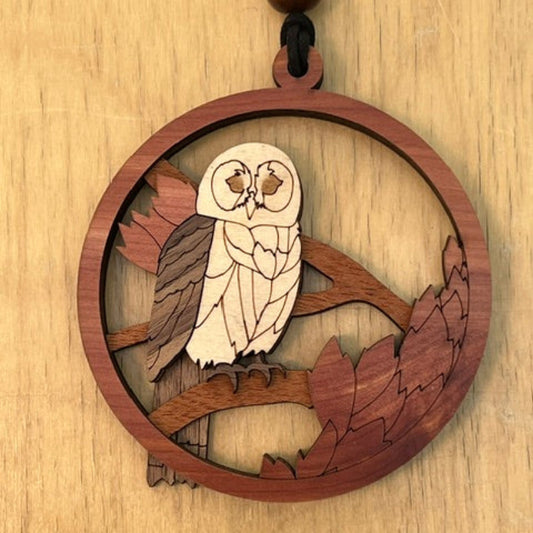 Wooden pendant with an owl design on a wooden background