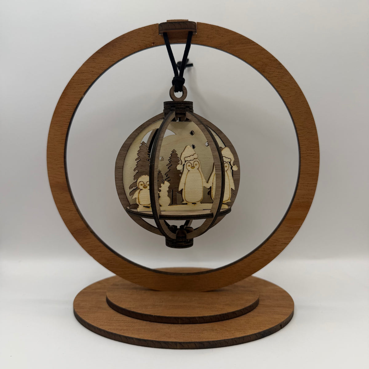 3D Penguins Family wood ornament shown in a display stand
