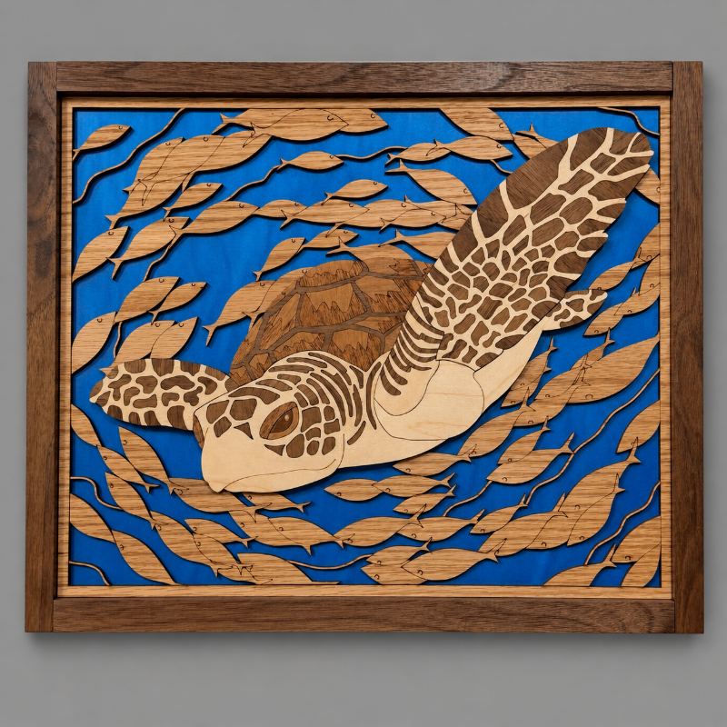 A square wooden wall art piece featuring a laser-cut sea turtle swimming among layered leaf shapes over a bright blue background, set in a medium brown wood frame against a neutral gray wall.