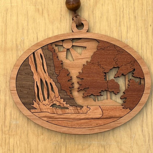 Wooden pendant featuring an intricate laser-cut waterfall design on a wooden surface