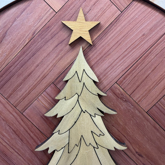 Close-up of the yellow canary wood star above the poplar Christmas tree on the oval wall art