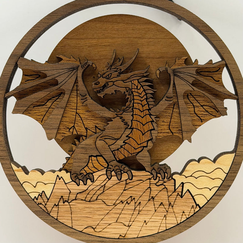 A circular wooden dragon wall hanging featuring a laser-cut dragon perched on mountains, with a sun and moon design in the background.