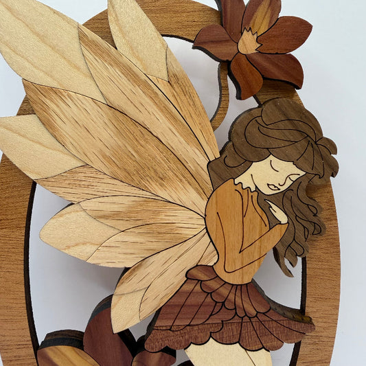 Close-up of the wooden fairy shelf sitter showing the cedar flowers and contrasting wood grain