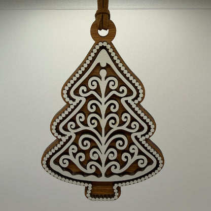 hanging ornament wood gingerbread tree with dark wood and white frosting overlay hanging on a brown cord