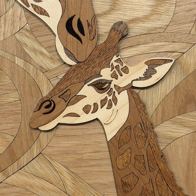 A close-up of a wooden giraffe head mosaic artwork, crafted from natural wood tones with detailed facial features and patterned wood inlay.
