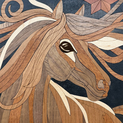 Close-up of a decorative wooden horse head artwork with layered wood inlays forming the face, mane, and dark blue background.