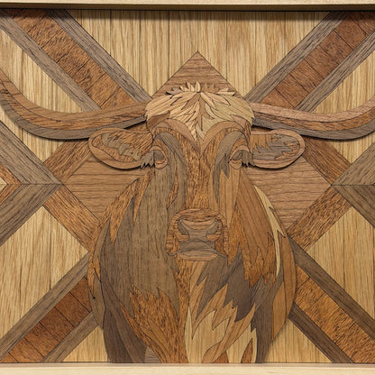 Intricately carved wooden wall art featuring a stylized longhorn steer head with layered wood grain patterns in warm tan, brown, and medium brown tones.
