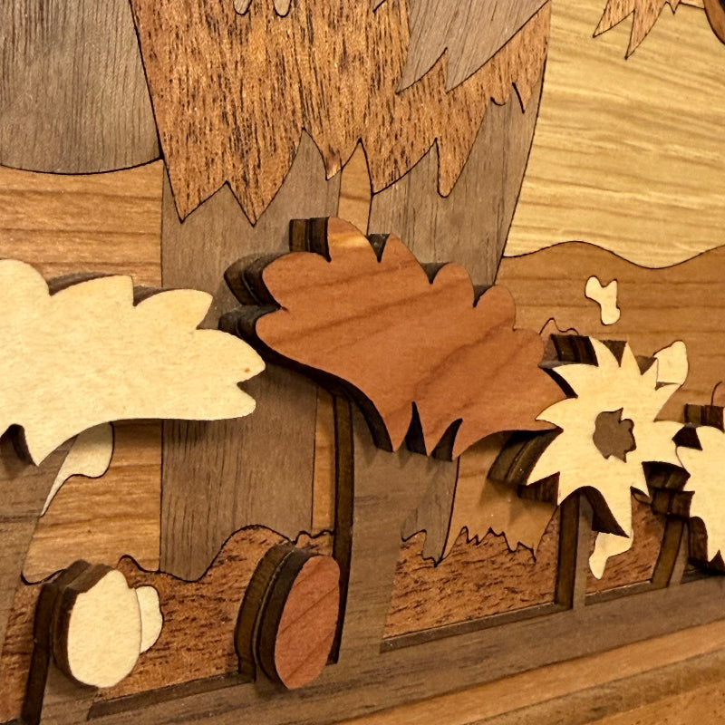 Close-up of a layered wooden wall art piece featuring stylized flowers in varying wood tones.