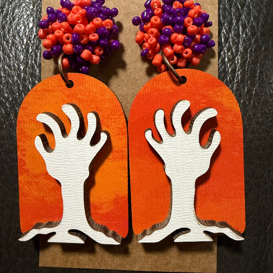 Tombstone with zombie hands earrings shown from another angle